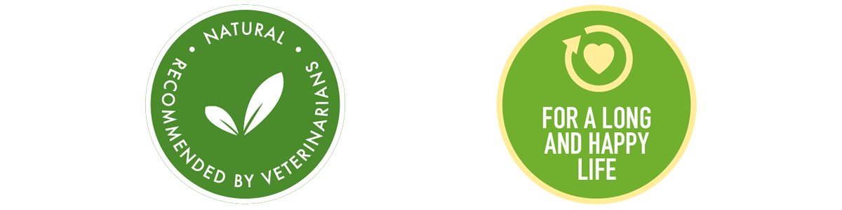 Green circular icons with yellow borders from the Selective Naturals Botanicals natural food for rabbits and guinea pigs packs. The first icon features a leaf graphic with the text 'Natural Recommended by Veterinarians.' The second icon shows a heart with an arrow around it and the text 'For a Long and Happy Life.'